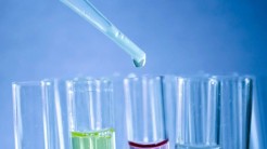 Pipette mit Tropfen über 5 Reagenzgläsern